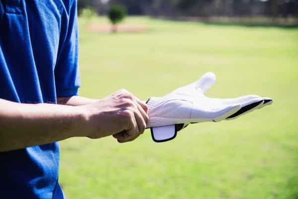Golfer putting on golf glove